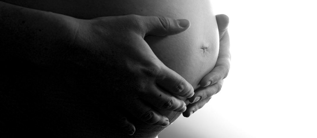 Deux main sur le ventre d'une femme enceinte